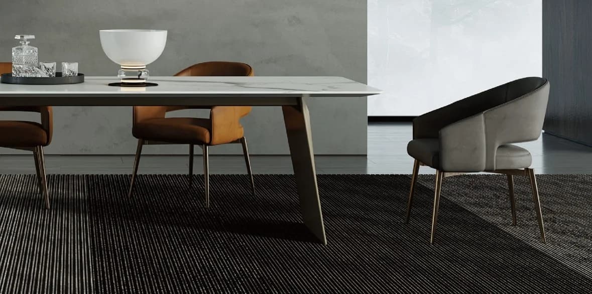 Mesa de comedor de líneas escultóricas junto a sillas tapizadas