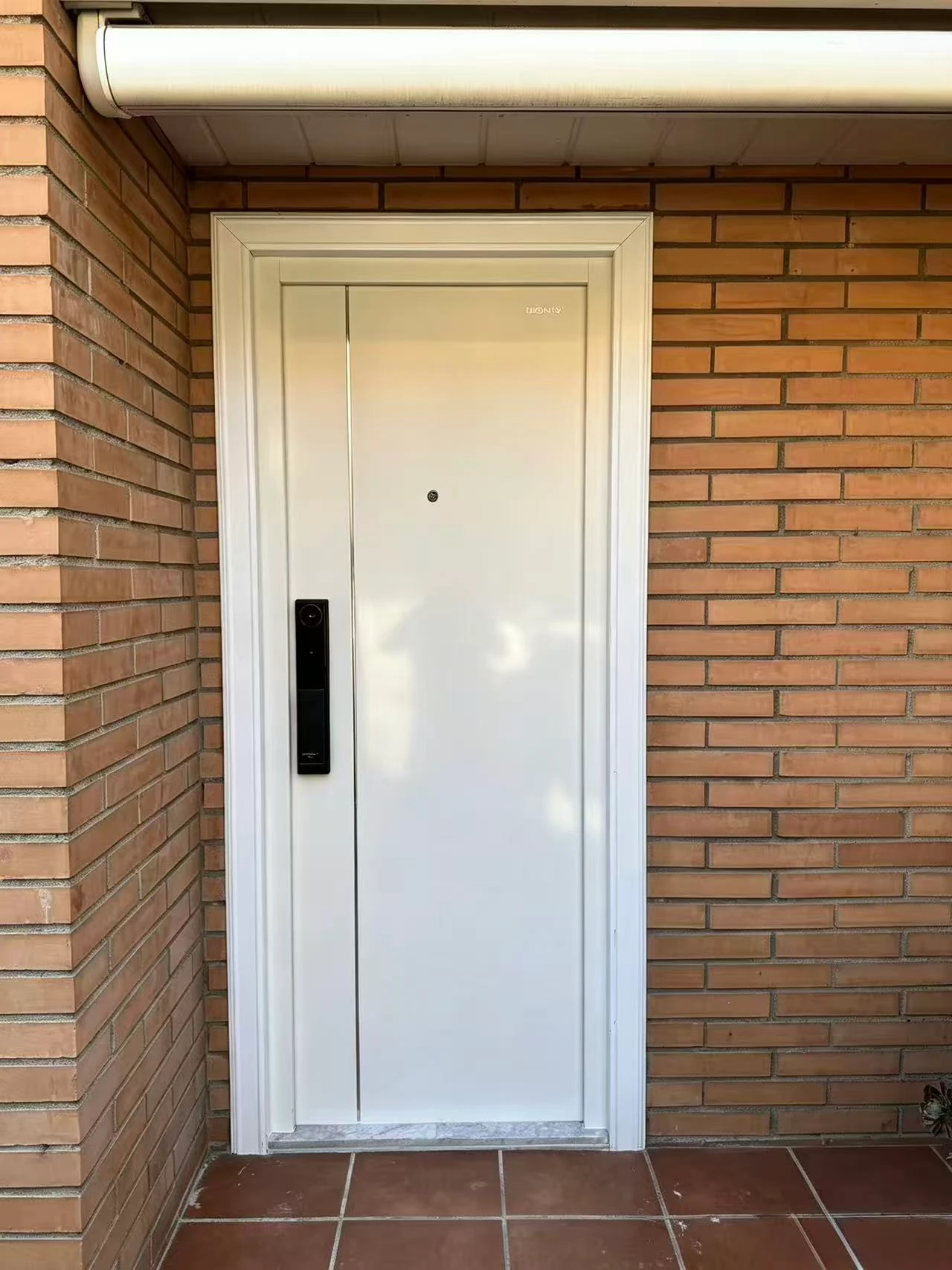 Nueva puerta de entrada blanca con cerradura inteligente instalada en Badalona