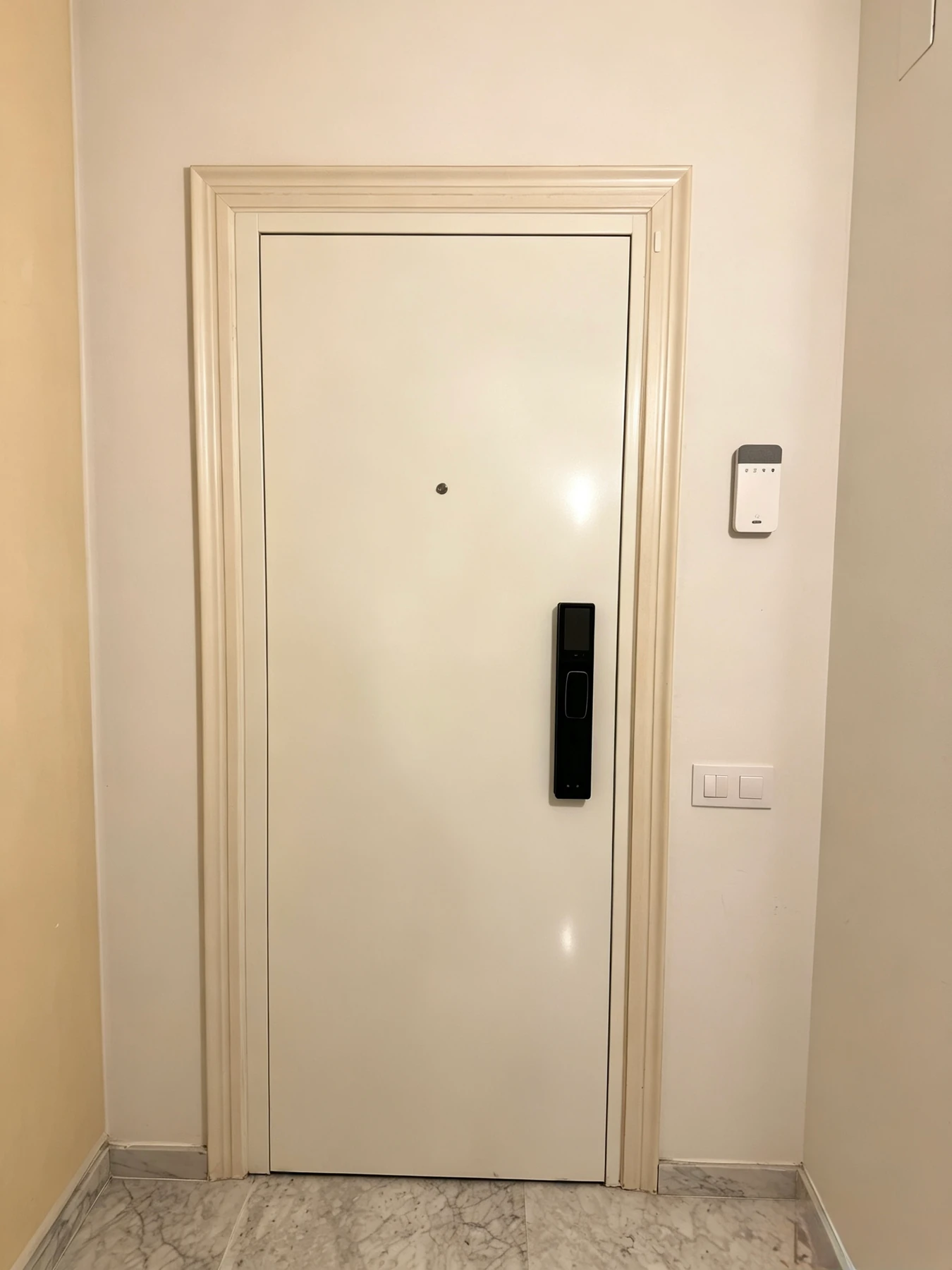 Vista interior de la nueva puerta blanca con cerradura inteligente en Badalona